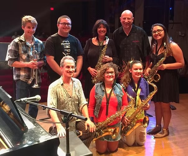 Students holding saxophones and brass instruments